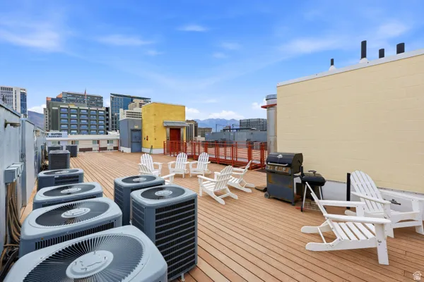 Rooftop deck featuring wood-finish flooring and urban surroundings