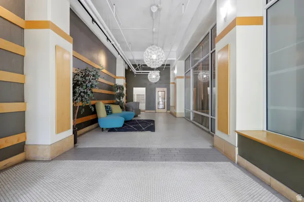 Expansive common area featuring a light-toned ceiling, hexagonal mosaic tile flooring, track lighting, and decorative pendant light fixtures