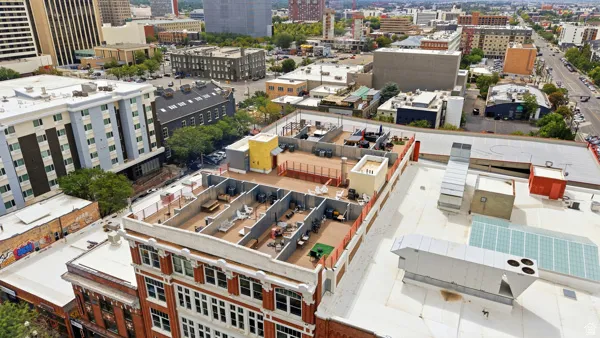 Rooftop deck featuring multiple defined outdoor lounge areas and cityscape surroundings