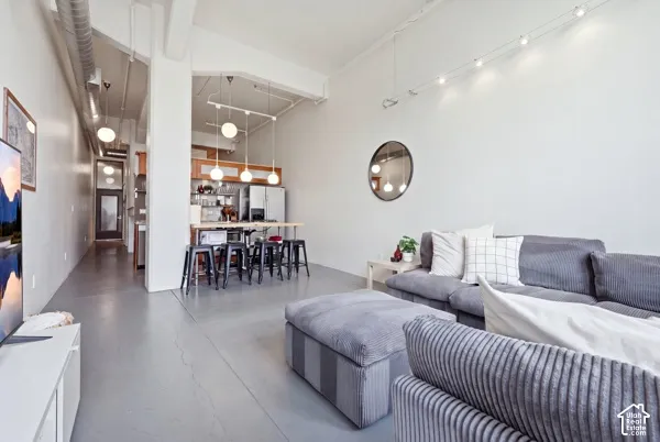 High ceilings featuring exposed ductwork, track lighting, and pendant fixtures