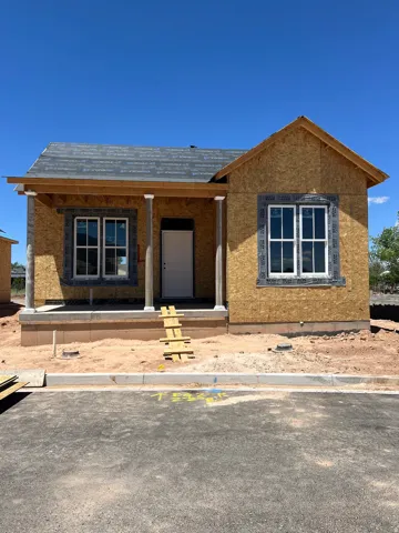 Newly constructed residence featuring a covered front porch, white-framed windows, and a prominent gable roofline