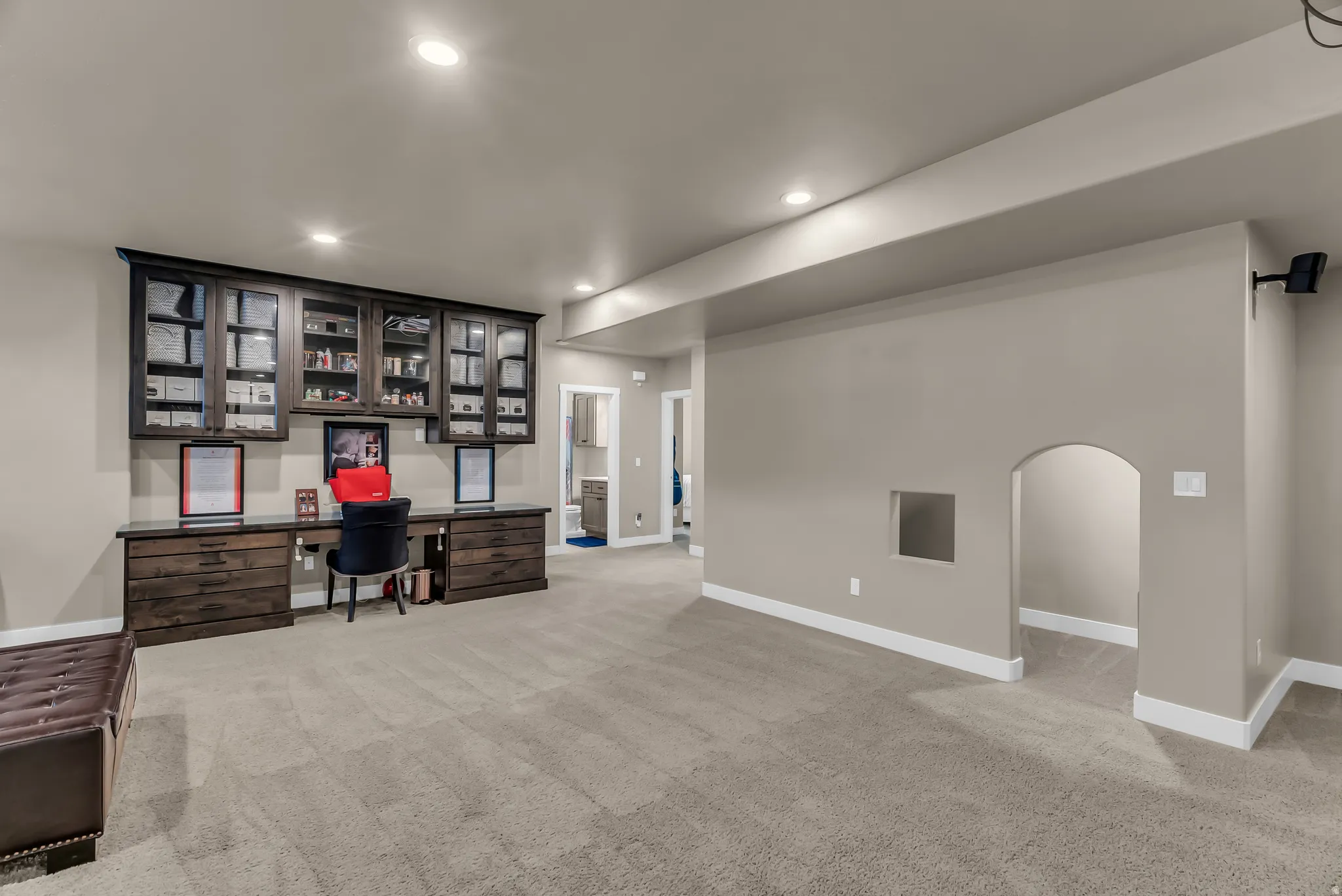 Built-in dark wood cabinetry with glass fronts and integrated desk space