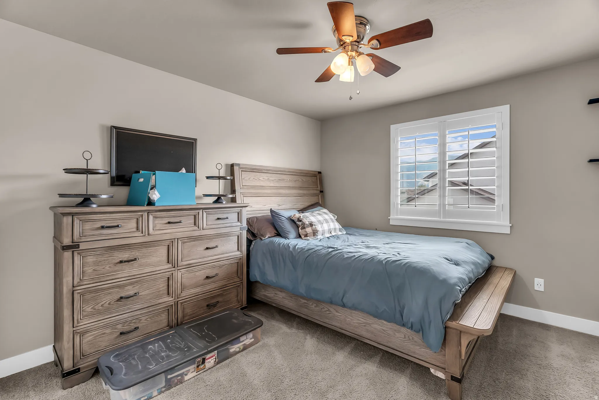 Recessed ceiling fan with integrated lighting, window with white plantation shutters, built-in shelving, light gray wall paint, and gray carpet