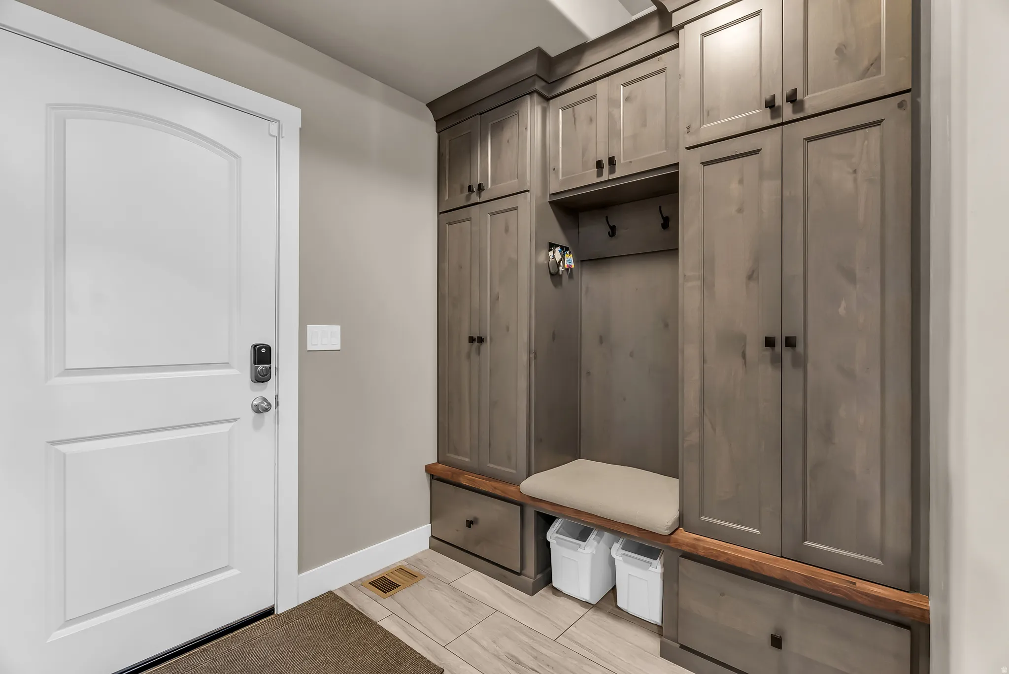 Built-in mudroom cabinetry with a bench, storage cubbies, and a wood-finish countertop
