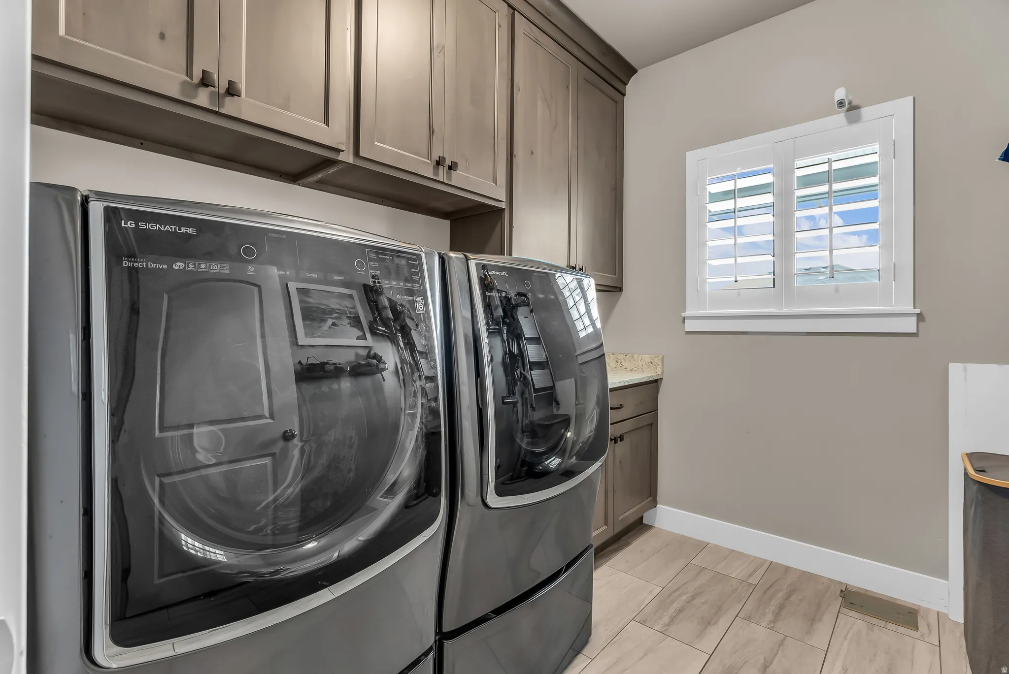 Built-in cabinetry, under-cabinet lighting, light-toned countertop, and wood-finish tile flooring