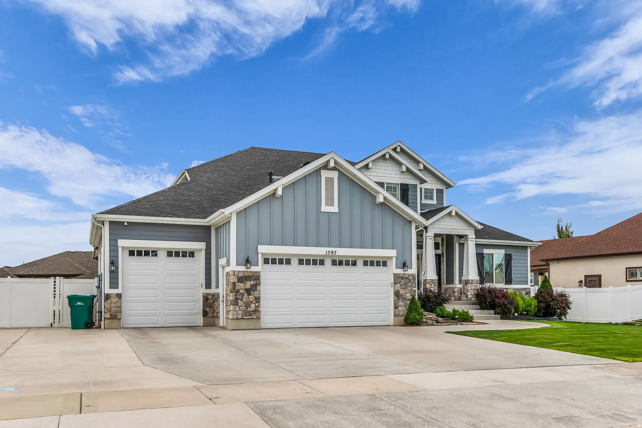 Contemporary home with stone accents, horizontal and vertical siding, a two-car garage, and a single-car garage