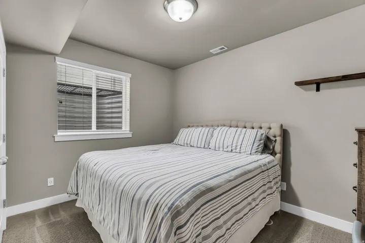 Carpeted flooring, recessed ceiling light, built-in wall shelf, and window with blinds