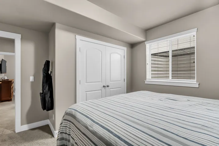 Recessed lighting, plush carpeting, white interior doors, and a window with white blinds