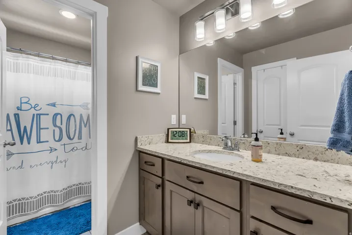 Extended vanity with an integrated sink, polished chrome faucet, and substantial mirror