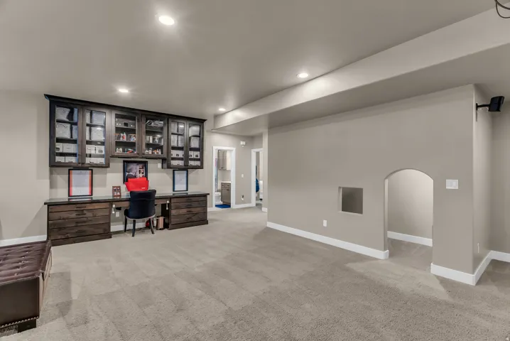 Built-in dark wood cabinetry with glass fronts and integrated desk space
