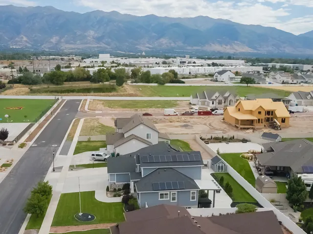 Mountain backdrop, newly constructed homes, paved roads, manicured lawns, solar panels