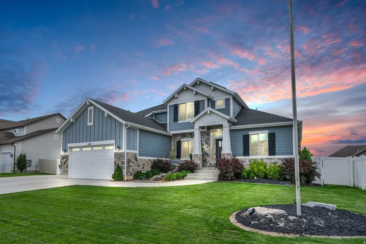 Two-story residence featuring a two-car garage, stone accents, and a covered entry