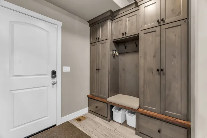 Built-in mudroom cabinetry with a bench, storage cubbies, and a wood-finish countertop