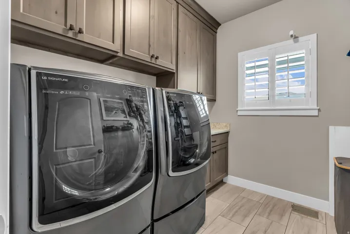 Built-in cabinetry, under-cabinet lighting, light-toned countertop, and wood-finish tile flooring