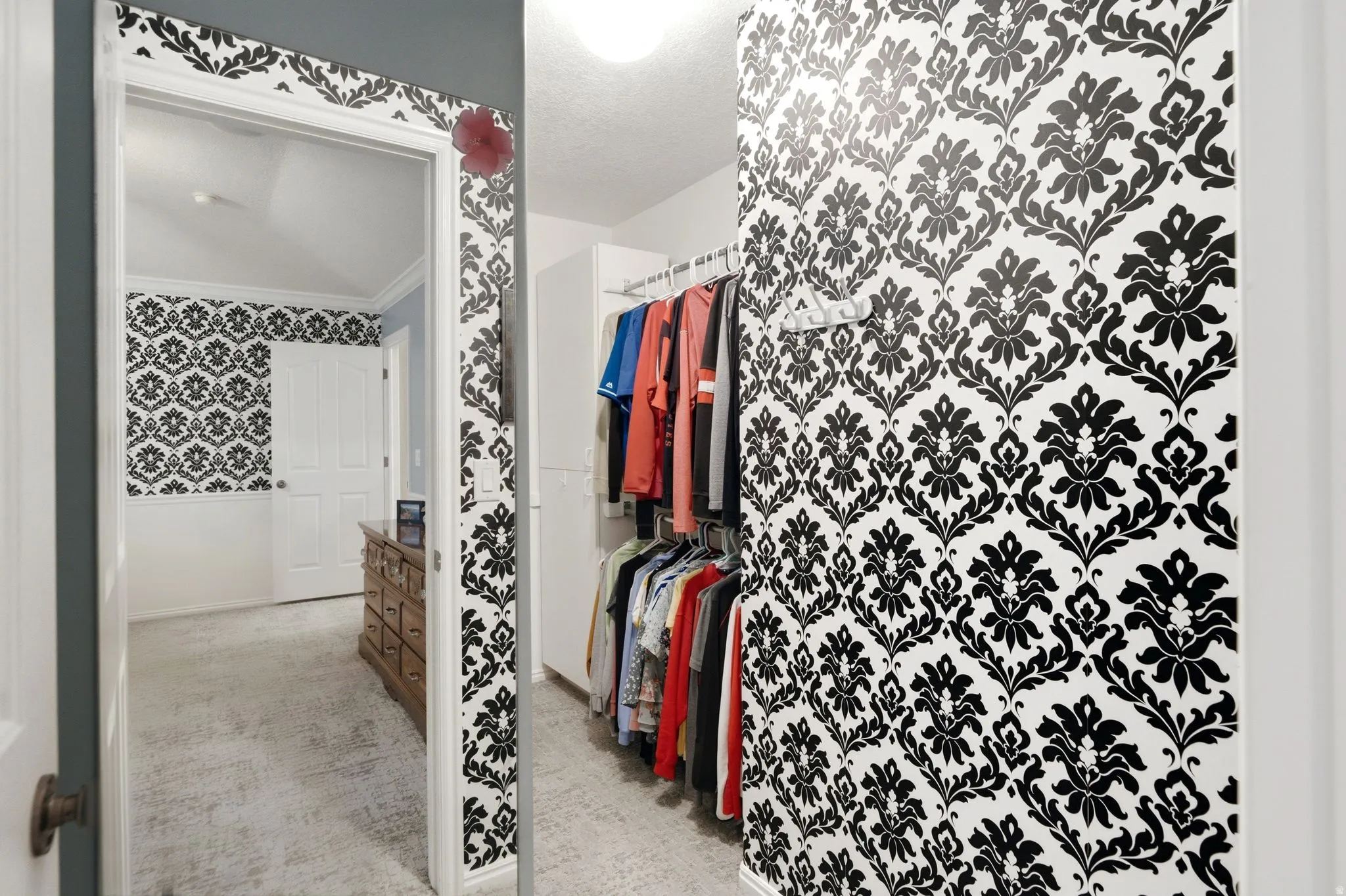 Wall-to-wall carpeting, decorative wallpaper, and built-in closet organization system