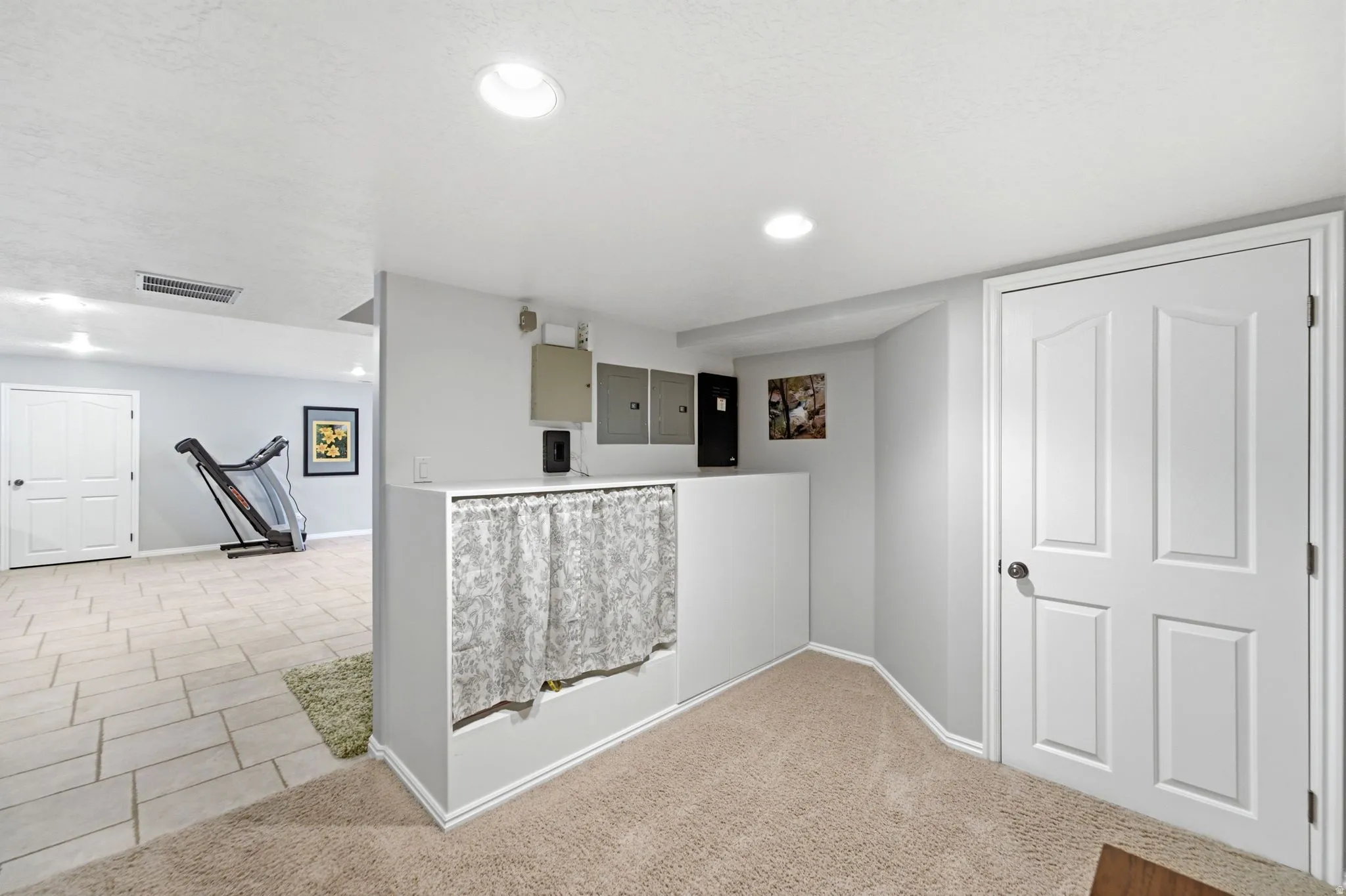 Recessed ceiling lighting, light-toned carpeting, tiled flooring, and a paneled door