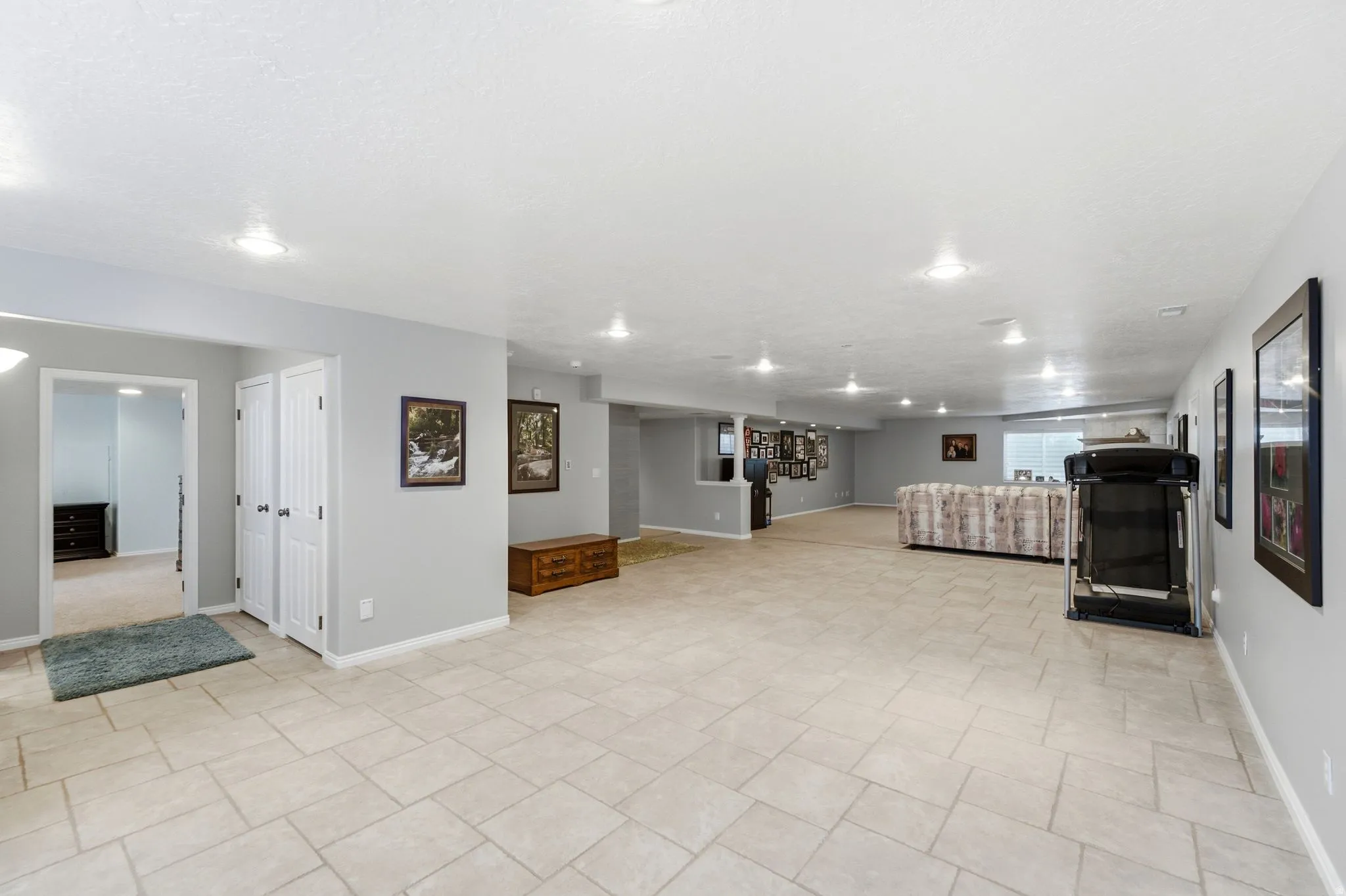 Spacious room with recessed lighting, light-toned tile flooring, and neutral wall paint