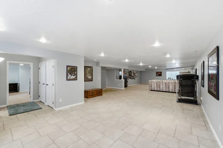 Spacious room with recessed lighting, light-toned tile flooring, and neutral wall paint
