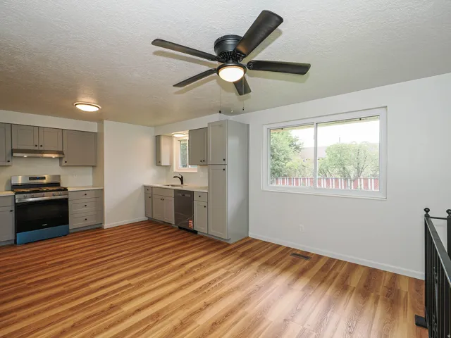 Open-concept living space with wood-finish flooring, recessed lighting, and a ceiling fan