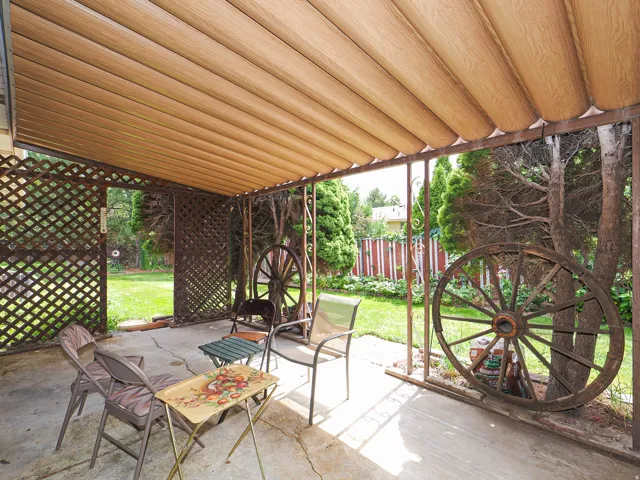 Covered patio with a wood-finish ceiling, latticework screening, and concrete flooring
