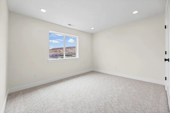 Recessed lighting, light neutral-toned walls, and carpet flooring