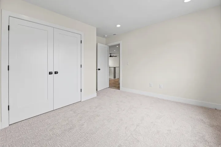 Neutral carpet flooring and recessed ceiling lighting