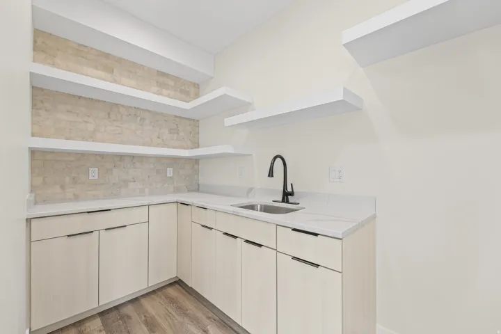 L-shaped countertop with an undermount sink and matte black faucet
