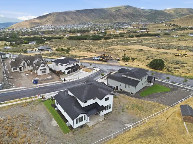Newly constructed residence featuring a white exterior, black roof, and manicured lawn