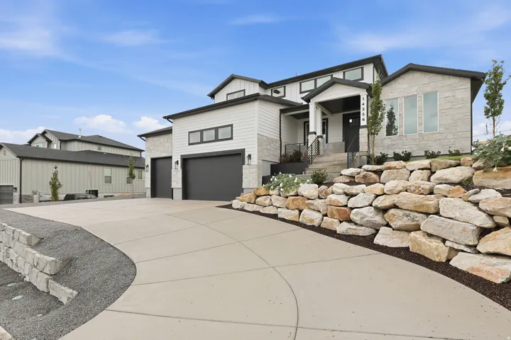 Modern exterior with white siding and stacked stone accents