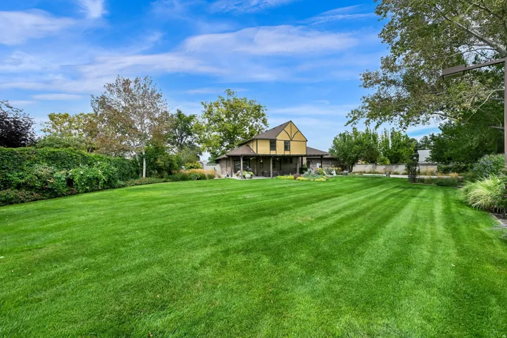 Expansive lawn featuring manicured grass, mature trees, and landscaping