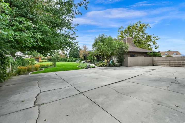 Expansive concrete paving and a grassy lawn with established trees