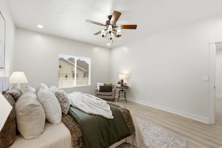 Recessed lighting, wood-finish flooring, and a ceiling fan with integrated lighting