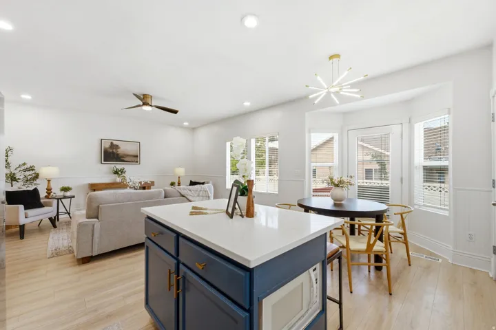 Open-concept living space featuring wood-finish flooring, recessed lighting, and a contemporary ceiling fan