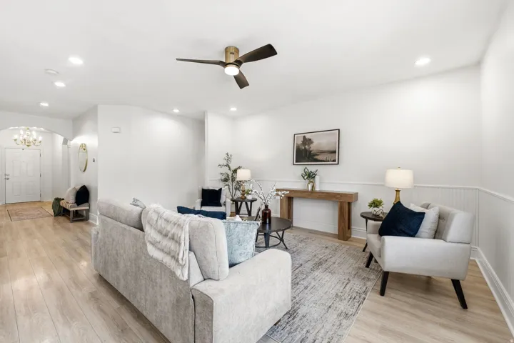 Recessed lighting, wood-finish flooring, ceiling fan with integrated light, wainscoting, and an arched entryway