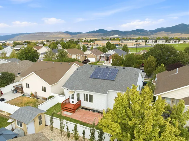 White-sided exterior with a gray shingle roof, featuring rooftop solar panels