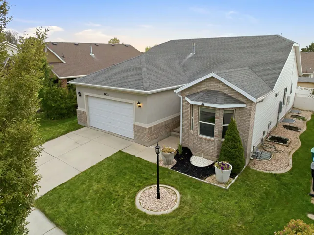 Property with a grey shingle roof, attached garage, and a bay window featuring a brick facade