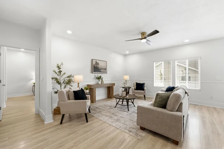Recessed lighting, wood-finish flooring, ceiling fan, multiple windows with blinds, and wainscoting