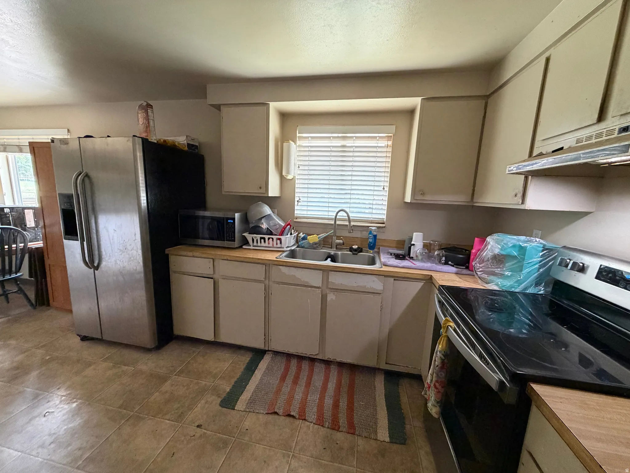 Kitchen with neutral cabinetry and wood-finish countertops