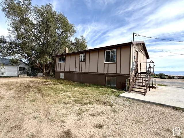 Brown-paneled exterior with white trim windows and metal exterior stairs
