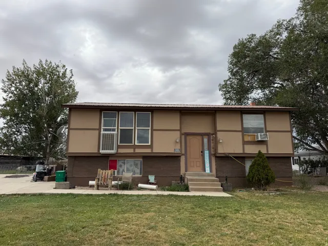Two-story exterior with a metal roof and a prominent front door