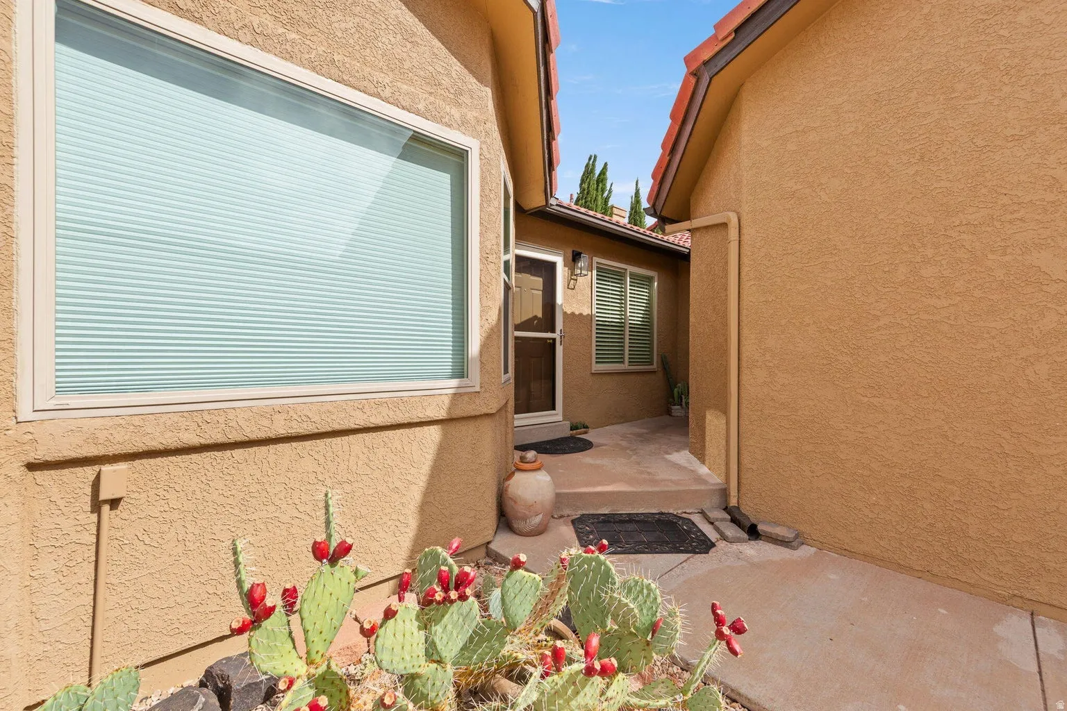 Stucco exterior with a terracotta tile roof accent