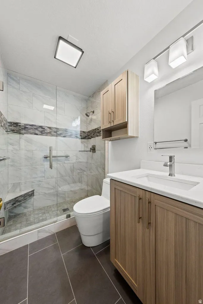 Walk-in shower with glass enclosure, integrated bench, and tiled walls