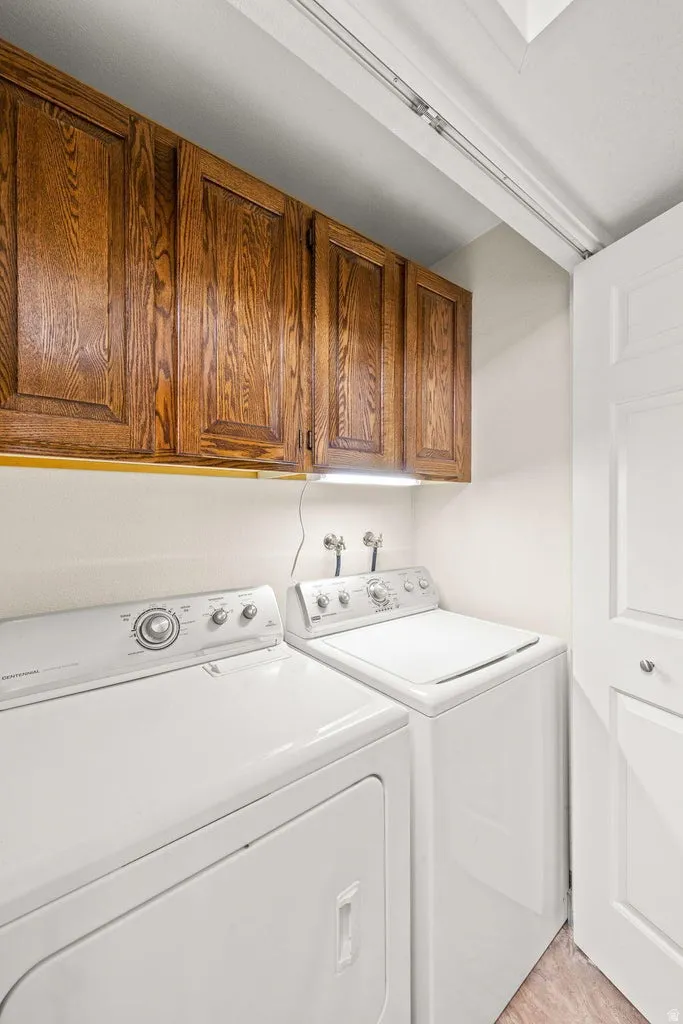 Built-in wood cabinetry, white appliances, and a light-toned flooring