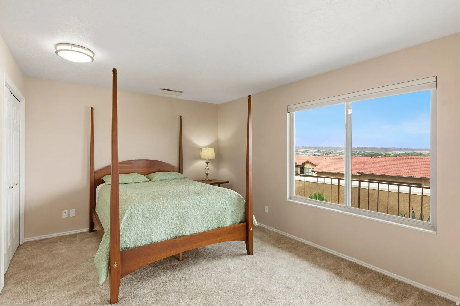 Neutral tone wall paint, carpeted flooring, built-in closet with bi-fold doors, recessed window, and flush-mount ceiling light