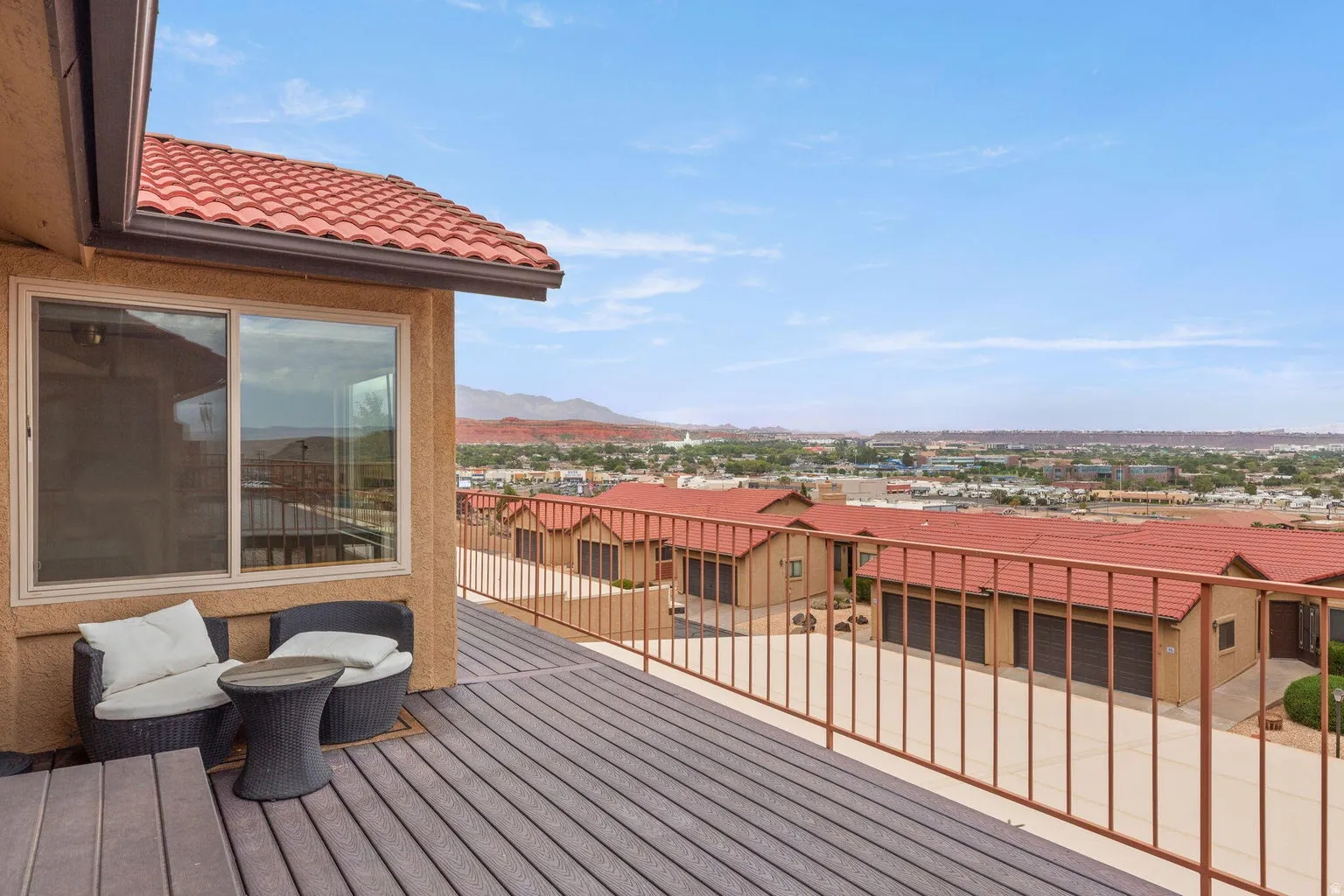 Expansive elevated deck with composite decking, metal railing, and a tile roof overhang