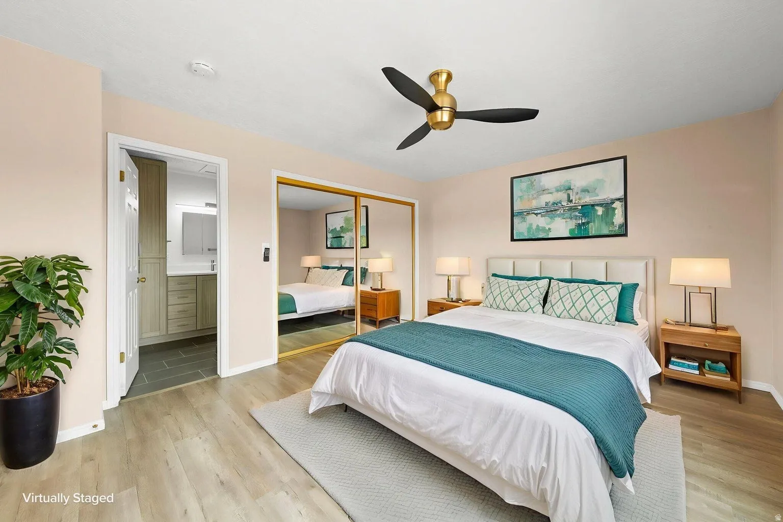 Wood-finish flooring with a ceiling fan featuring a gold-tone base and black blades