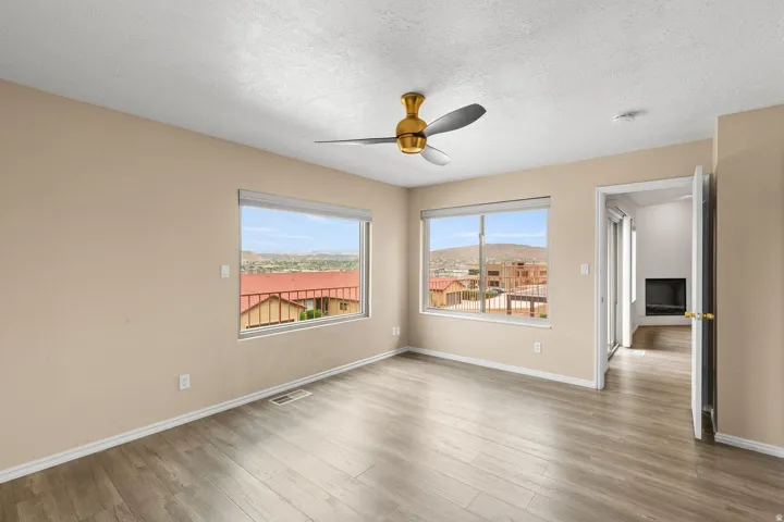 Wood-finish flooring, recessed windows, ceiling fan, and painted walls