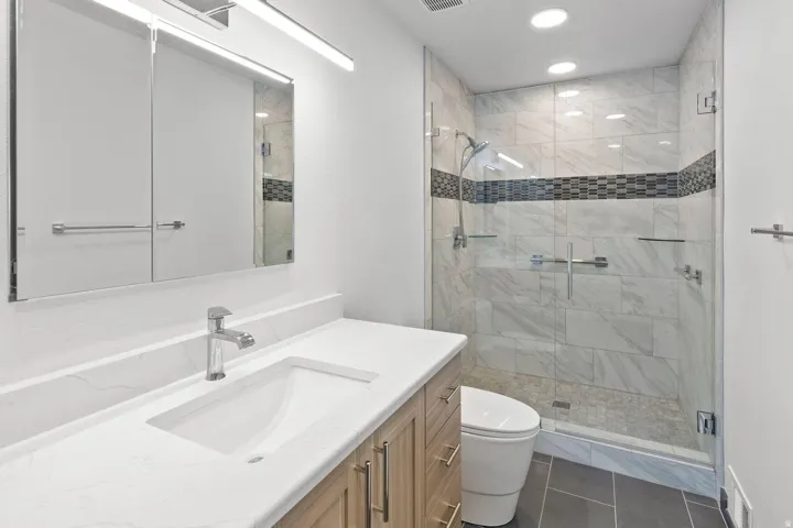 Vanity with integrated sink, chrome faucet, and mirrored medicine cabinet