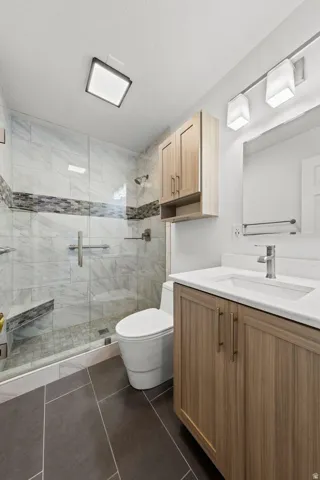 Walk-in shower with glass enclosure, integrated bench, and tiled walls