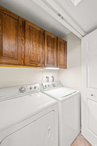 Built-in wood cabinetry, white appliances, and a light-toned flooring